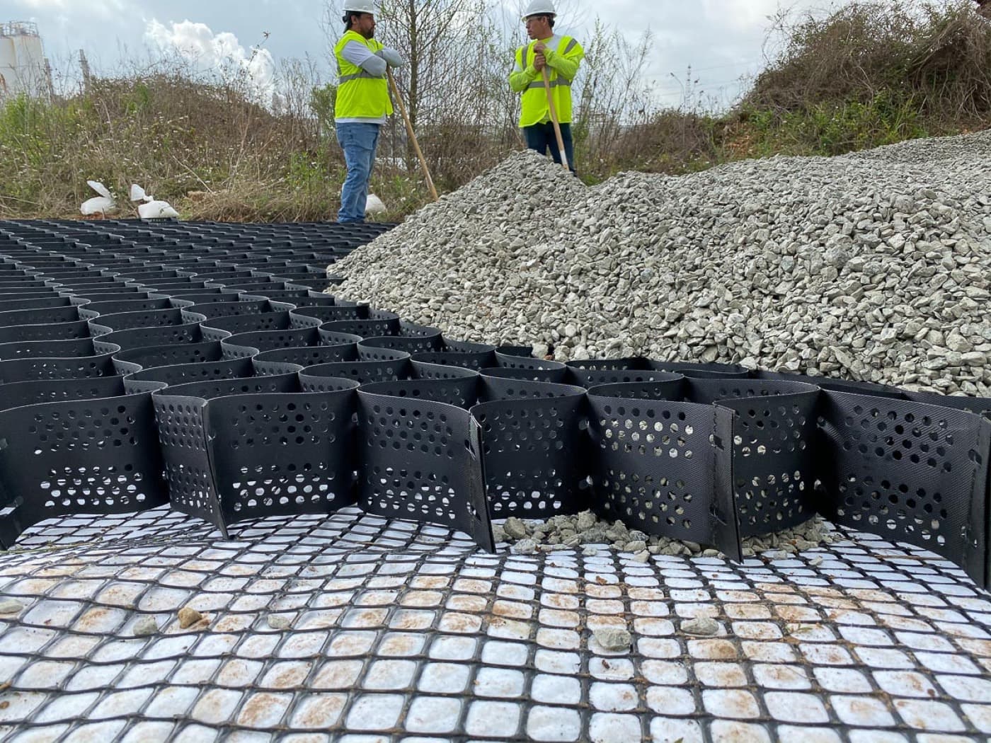 Aggregate being spread into the cells, over a base geogrid