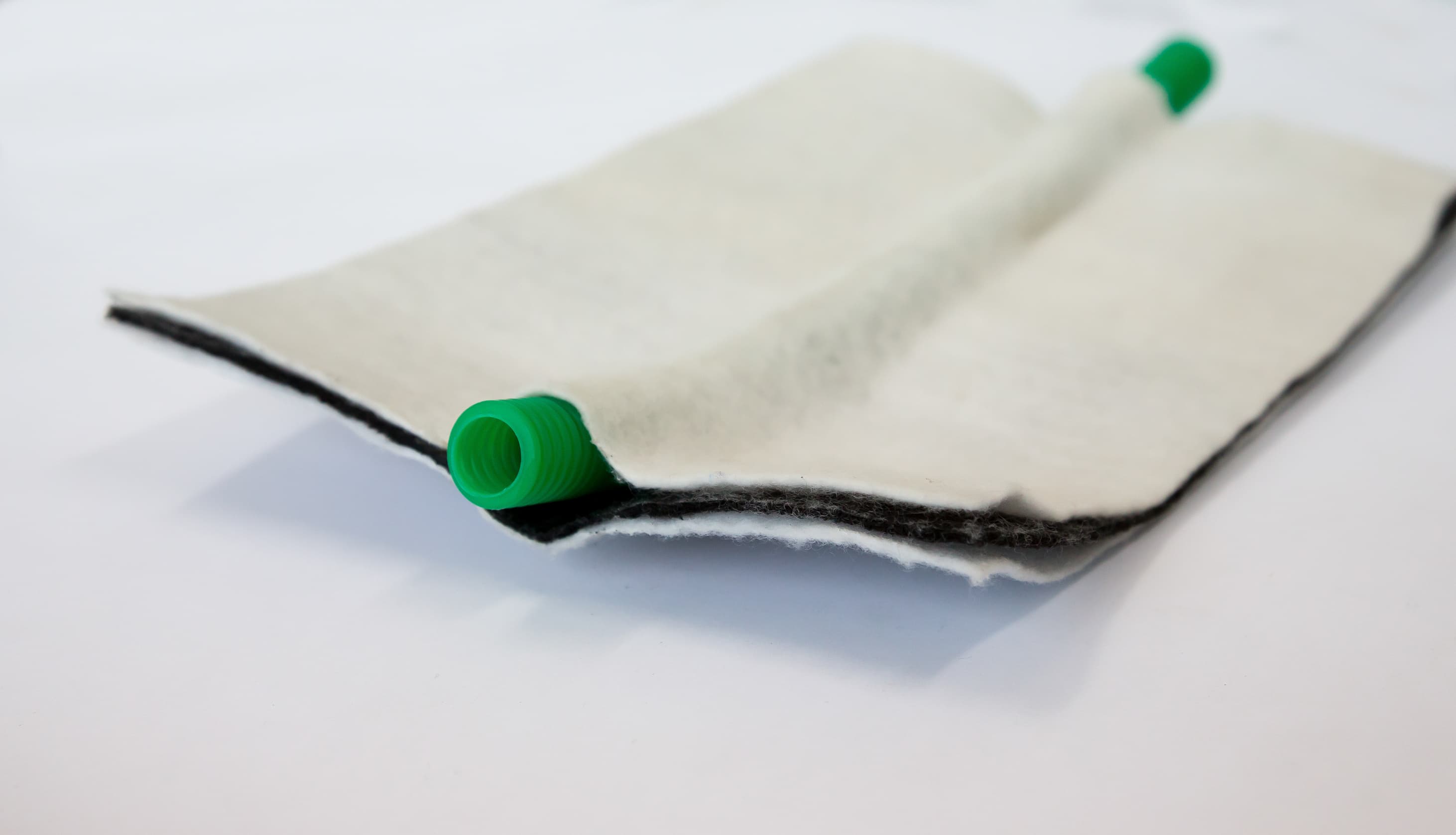 TALDRAIN drainage geocomposite roll showing integrated corrugated mini-drain pipe